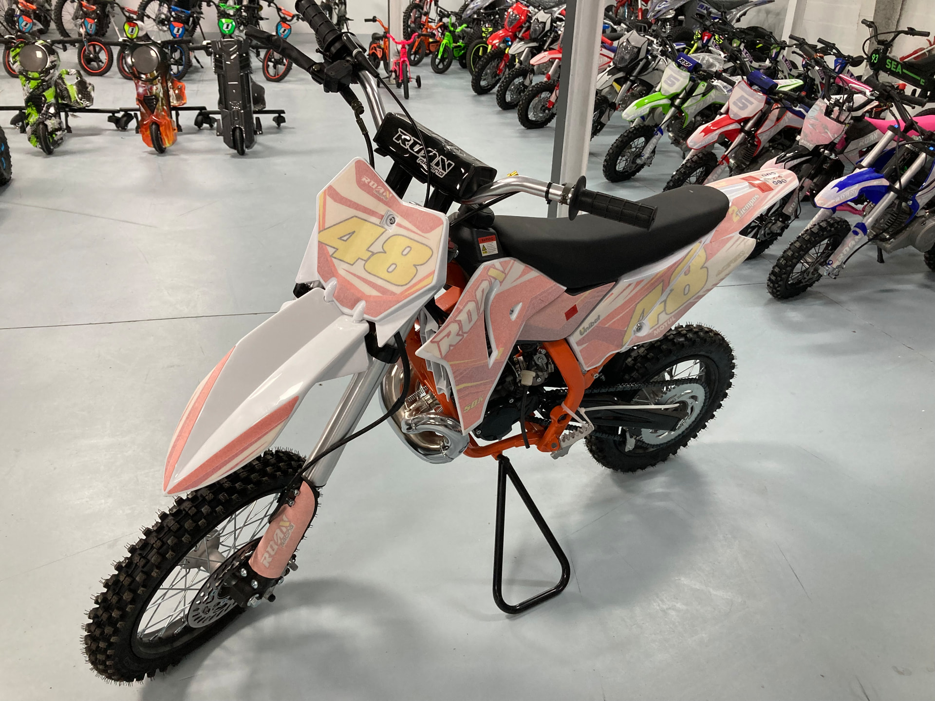 Minicross de competición naranja y blanca con el dorsal 48