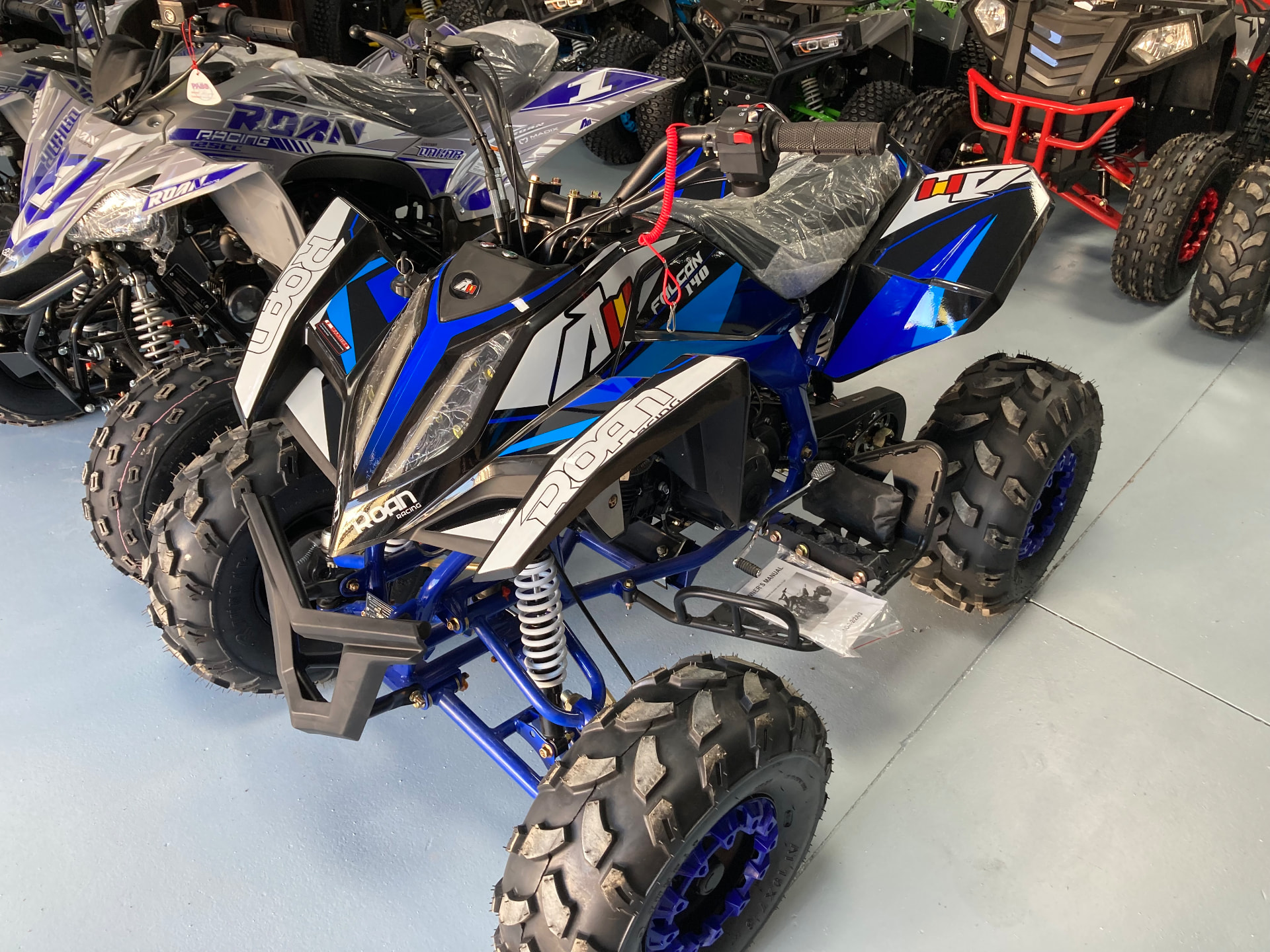 Quad deportivo ROAN Racing Falcon 140 en azul, negro y blanco en la exposición